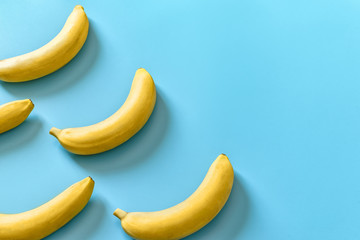 Five bananas on a blue pastel background. Minimal concept.