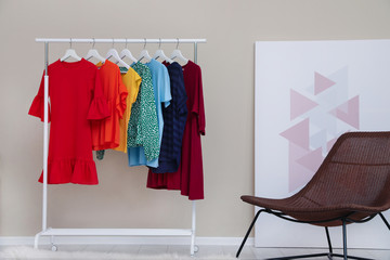 Wardrobe rack with colorful clothes in stylish room