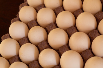 Many white chicken eggs on cardboard and with shadows
