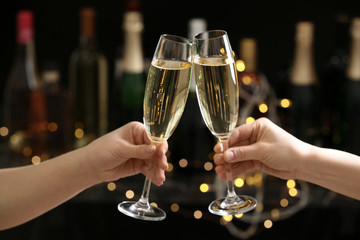 People clinking glasses of champagne on blurred background, closeup
