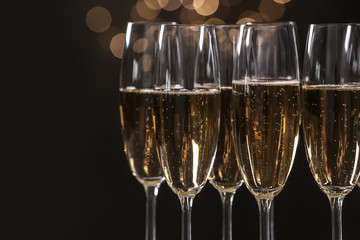Glasses of champagne on blurred background, closeup. Space for text