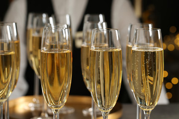 Glasses of champagne and waiter in restaurant, closeup