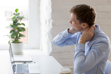 Millennial tired man having a neck pain