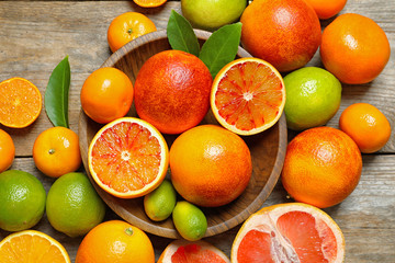 Flat lay composition with different citrus fruits on wooden background