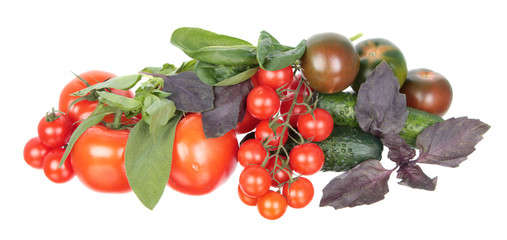 Fresh different red tomatoes, green cucumbers, purple and green basil and sage leaves isolated on white background. Ingredients for vegetable salad