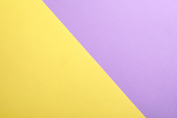 Violet and yellow paper sheets as colorful background, top view