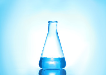 Laboratory flask with liquid on color background. Solution chemistry