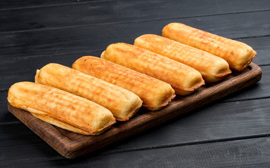 Home made corn dogs, on a dark wooden background. Classic american food