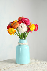 Vase with beautiful ranunculus flowers on table