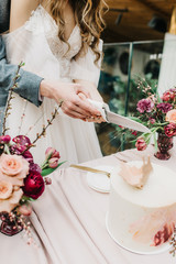Newlyweds are cutting a wedding cake