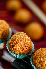 Vegan sweets/ Raw food nutty sweets on a beautiful red violin close-up. Healthy sweets. Desserts without sugar, milk and flour. Series of photos. Close-up. Space