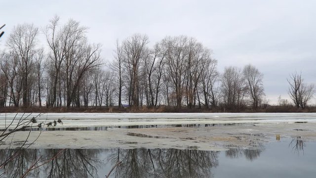 Melting the last ice on the river in early spring on a cloudy day. Flood on the river. Camera panning