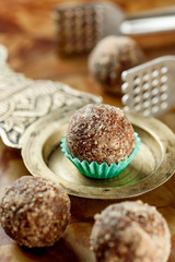 Beautiful raw/vegan desserts with nuts on a copper saucer on a wooden table. Close-up