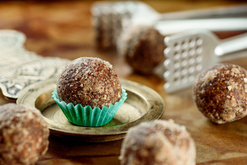 Beautiful raw/vegan desserts with nuts on a copper saucer on a wooden table. Close-up