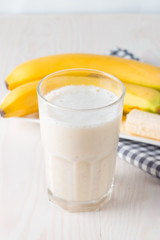Fresh Made Chocolate Banana Smoothie on a wooden table. Selective focus. Milkshake with almonds. Protein diet. Healthy food and drink concept.