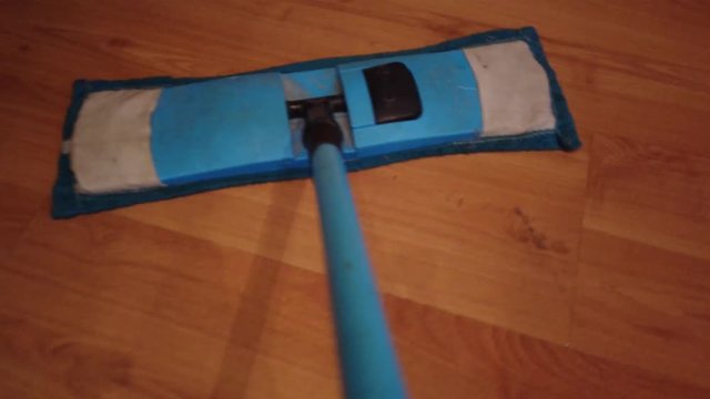 Young man with Mop, Cleaning Floor at Home. Man Sweeps Dust in room and brings Order and Cleanliness in House - Housework and Housekeeping concept.