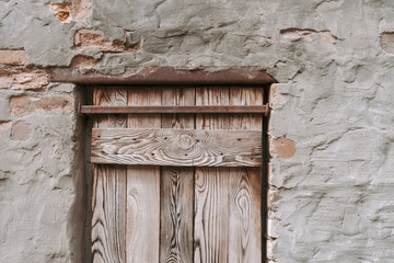 Fototapeta na wymiar Wooden door in old stone wall background.
