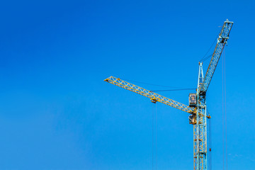 Two cranes against the blue sky.