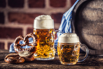 Oktoberfest large and small beer with pretzel wooden barrel and blue tablecloth
