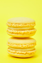 Two macarons on yellow background