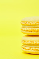 Two macarons on yellow background