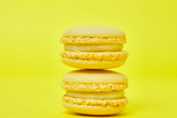 Two macarons on yellow background