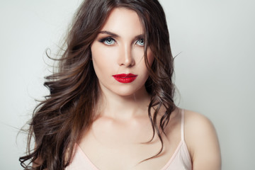 Elegant model woman with long brown hair and red lips make up on white background
