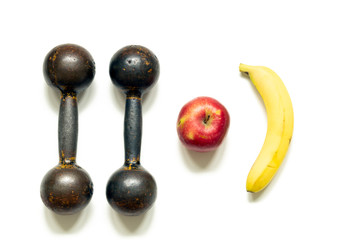 Two dumbbells Apple and banana on white background, top view. The concept of a healthy diet and a healthy lifestyle.