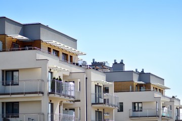 Fototapeta premium Modern apartment buildings on a sunny day with a blue sky. Facade of a modern apartment building