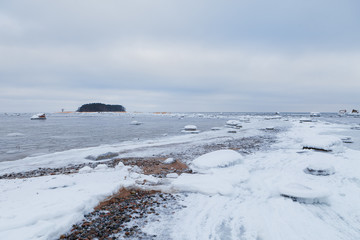Fototapeta premium Stones under snow and ice along the coast of Baltic sea. Kasmu peninsula, Estonia.