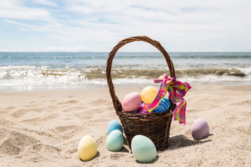 Beach Happy Easter background with basket and color eggs