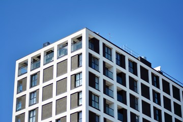 Obraz premium Nowoczesne budynki mieszkalne w słoneczny dzień z błękitnym niebem. Fasada nowoczesnego apartamentowca