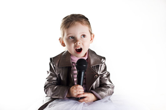 Portrait of a toddler girl singing in microphone