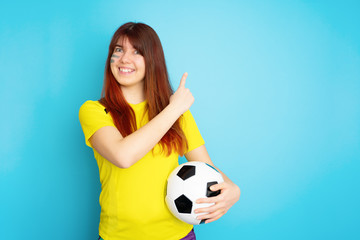 Woman is socccer fan in yellow t-shirt with soccer ball