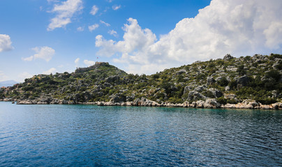 a view of the yacht on the blue waters and the various mountain scenery on the blue sky; travel pleasure in summer