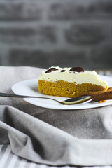 Food, culinary, baking and holidays concept. Vertical. Cinamon.  Piece of Biscuit cake with cream filling. Homemade Biscuit cake arranged on white plate.