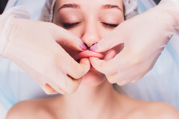 cosmetologist makes a buccal massage of the patient's facial muscles.