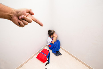 Boy alone being accused by an adult hand. Concept of scolding or punishment. Image about fear and...