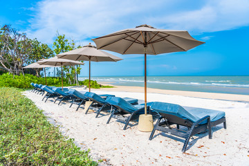 Umbrella and chair on the beach sea ocean with blue sky and white cloud