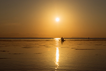Silhouette of a couple on a boat in the sea at sunset