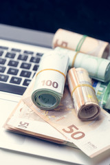 Euro notes and computer. Concept of modern earning of large money.