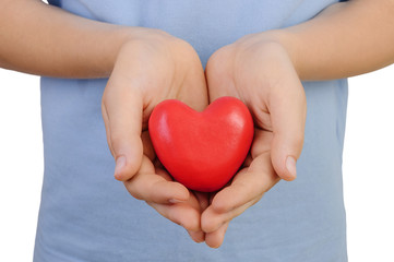 Heart in the hands of a boy on a white background. Concept of love or kindness.