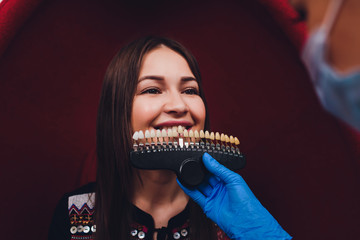 Dentist curing female patient Woman teeth examined at dentists teeth whitening. stomatology office...