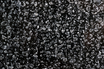 Marks left by dried water drops on glass. Close up shot against dark background
