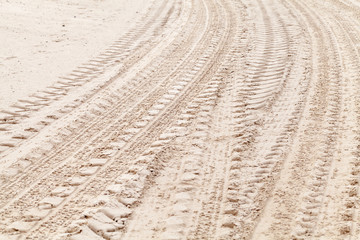 Turning tire tracks on white sand