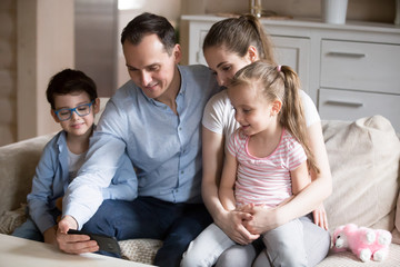 Whole family watching funny video on smartphone at home