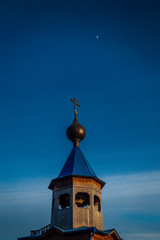 The setting sun illuminates the tops of the domes of the Orthodox Church