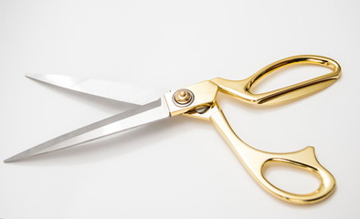 golden metal scissors for cutting lie on a white background