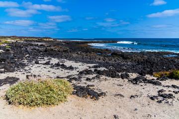 Spain, Lanzarote, Rough black lava and white sand at north orzola coast of the island