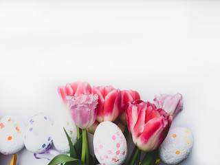 Easter eggs with tulips on a white surface